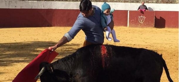 Il torero con la neonata in braccio infilza il toro e posta la foto sui social: è bufera